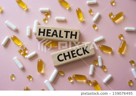HEALTH CHECK symbol. Concept word HEALTH CHECK on wooden blocks. Beautiful pink background with pills. Medicine and HEALTH CHECK. Copy space HEALTH CHECK symbol. Concept word HEALTH CHECK on wooden blocks. Beautiful pink background with pills. Medicine and HEALTH CHECK. Copy space 139076495