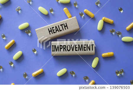 Health improvement symbol. Concept word Health improvement on wooden blocks. Beautiful purple background with pills. Medicine and Health improvement. Copy space Health improvement symbol. Concept word Health improvement on wooden blocks. Beautiful purple background with pills. Medicine and Health improvement. Copy space 139076503