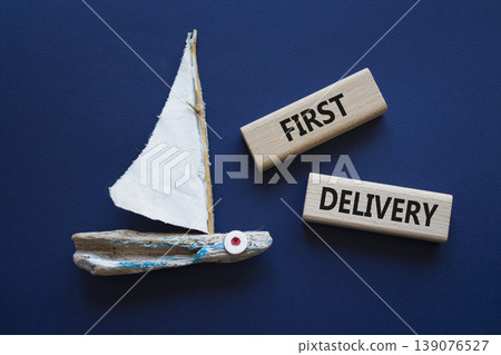 FIRST DELIVERY symbol. Concept word FIRST DELIVERY on wooden blocks. Beautiful deep blue background with boat. Business and FIRST DELIVERY concept. Copy space 139076527
