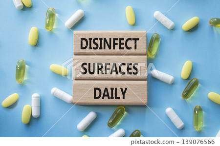 DISINFECT SURFACES DAILY symbol. Concept words DISINFECT SURFACES DAILY on wooden blocks. Beautiful blue background with pills. Healthcare and DISINFECT SURFACES DAILY concept. Copy space. DISINFECT SURFACES DAILY symbol. Concept words DISINFECT SURFACES DAILY on wooden blocks. Beautiful blue background with pills. Healthcare and DISINFECT SURFACES DAILY concept. Copy space. 139076566