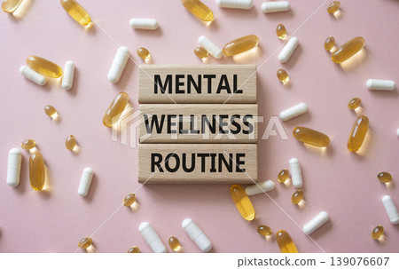 MENTAL WELLNESS ROUTINE symbol. Concept words MENTAL WELLNESS ROUTINE on wooden blocks. Beautiful pink background with pills. Healthcare and MENTAL WELLNESS ROUTINE concept. Copy space. MENTAL WELLNESS ROUTINE symbol. Concept words MENTAL WELLNESS ROUTINE on wooden blocks. Beautiful pink background with pills. Healthcare and MENTAL WELLNESS ROUTINE concept. Copy space. 139076607