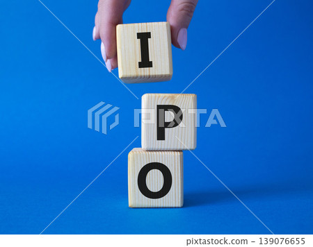 IPO- Initial Public Offering symbol. Concept word IPO on wooden cubes. Businessman hand. Beautiful blue background. Business and IPO concept. Copy space. 139076655