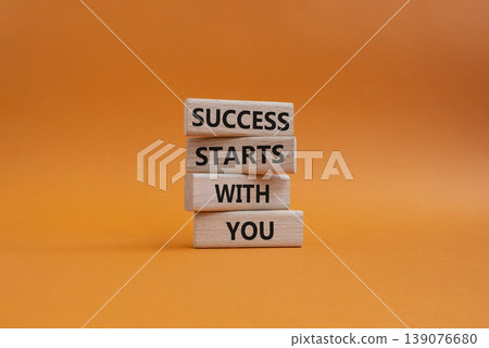 Success symbol. Wooden blocks with words Success Starts With You. Beautiful orange background. Business and Success concept. Copy space Success symbol. Wooden blocks with words Success Starts With You. Beautiful orange background. Business and Success concept. Copy space 139076680