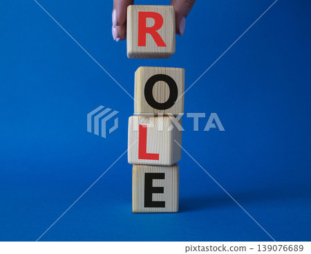 Role symbol. Concept word Role on wooden cubes. Businessman hand. Beautiful blue background. Business and Role concept. Copy space. Role symbol. Concept word Role on wooden cubes. Businessman hand. Beautiful blue background. Business and Role concept. Copy space. 139076689