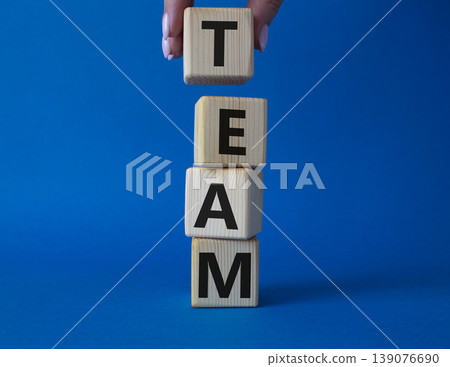 Team symbol. Concept word Team on wooden cubes. Businessman hand. Beautiful blue background. Business and Team concept. Copy space. Team symbol. Concept word Team on wooden cubes. Businessman hand. Beautiful blue background. Business and Team concept. Copy space. 139076690