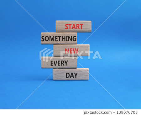 New symbol. Wooden blocks with words Start Something New Every Day. Beautiful blue background. Business and New concept. Copy space 139076703
