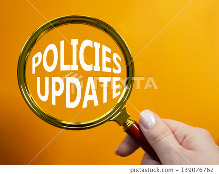 Policies Update symbol. Magnifying Glass with words Policies Update. Businessman hand. Beautiful orange background. Business and Policies Update concept. Copy space. Policies Update symbol. Magnifying Glass with words Policies Update. Businessman hand. Beautiful orange background. Business and Policies Update concept. Copy space. 139076762