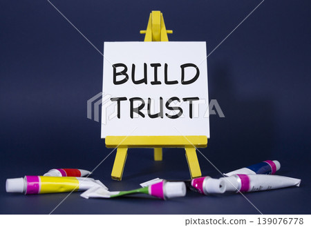 Build trust symbol. Wooden blocks with words Build trust. Beautiful deep blue background with paints and easel. Business and Build trust concept. Copy space. Build trust symbol. Wooden blocks with words Build trust. Beautiful deep blue background with paints and easel. Business and Build trust concept. Copy space. 139076778