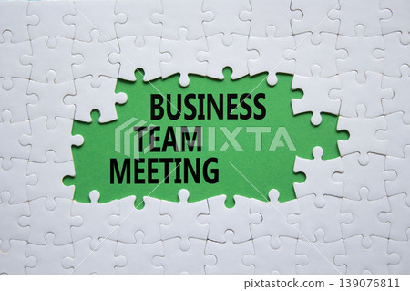 Business Team Meeting symbol. White puzzle with words Business Team Meeting. Beautiful green background. Business concept. Copy space. 139076811