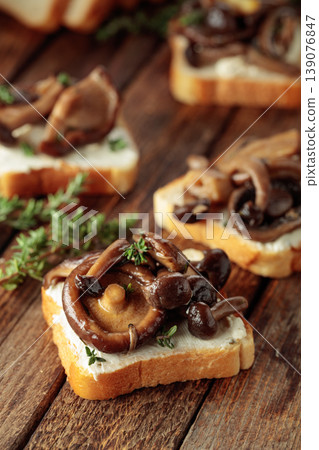 Sandwiches with baked mushrooms on an old wooden table. Sandwiches with baked mushrooms on an old wooden table. 139076847