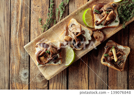 Sandwiches with baked mushrooms on an old wooden table. Sandwiches with baked mushrooms on an old wooden table. 139076848