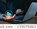 A person using a laptop and smartphone holds a glowing digital 0% symbol hovering above their hand, representing technology, finance, innovation, and zero interest or no-fee online offers. 139076862