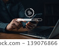Person updating software on smartphone with laptop on desk, concept of technology maintenance, system upgrade, mobile app update, digital progress, and data improvement. 139076866