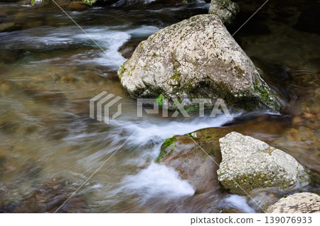 A crystal-clear river flowing between rugged rocks. A crystal-clear river flowing between rugged rocks. 139076933