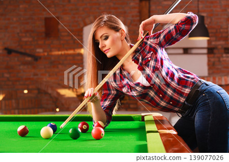 Young woman playing billiard. Young woman playing billiard. 139077026