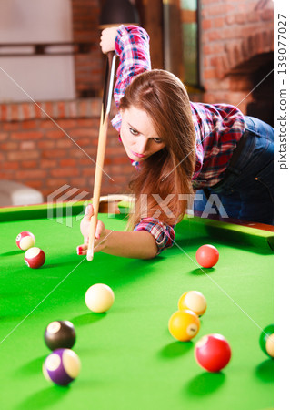 Young woman playing billiard. Young woman playing billiard. 139077027