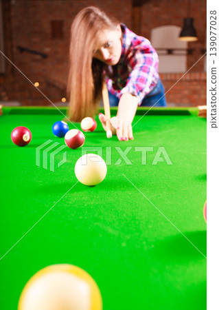 Young fashionable girl playing billiard. Young fashionable girl playing billiard. 139077028
