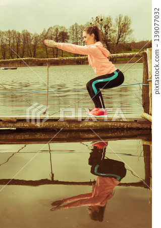 Girl training in sporty clothes on lake shore Girl training in sporty clothes on lake shore 139077032