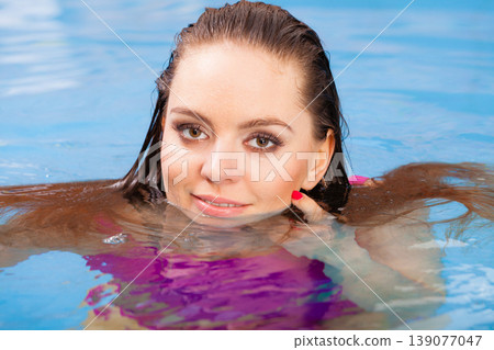woman enjoying the water in swimming pool 139077047