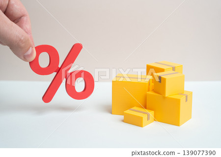 Boxes of goods and a red percentage show new taxes on imports. Tariffs increase costs. Trade policy changes impact pricing and international business operations. Boxes of goods and a red percentage show new taxes on imports. Tariffs increase costs. Trade policy changes impact pricing and international business operations. 139077390