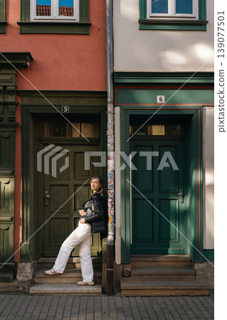 Woman Standing Between Colorful Doorways on Urban Street Woman Standing Between Colorful Doorways on Urban Street 139077501