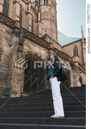 Woman Standing on Cathedral Steps and Looking at Historic Architecture Woman Standing on Cathedral Steps and Looking at Historic Architecture 139077533