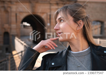 Stylish Woman Touching Chin Near Historic City Gate 139077547