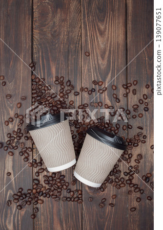 dark plank background, hot take-away coffee on a wooden table, coffee beans . top view, copyspace. dark plank background, hot take-away coffee on a wooden table, coffee beans . top view, copyspace. 139077651
