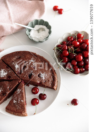 Summer Chocolate Cherry Cake with Slices on White Table Summer Chocolate Cherry Cake with Slices on White Table 139077659