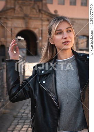 Stylish Woman Raising Hand Near Historic Stone Archway 139077740