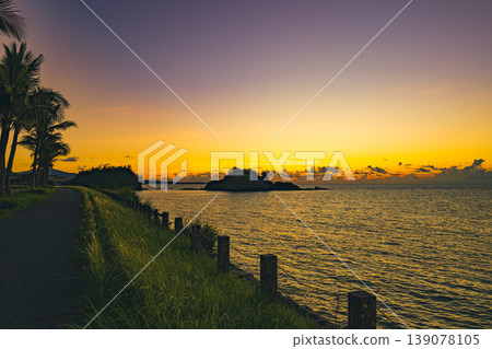 沖繩的景色美不勝收,夕陽灑在沙灘和棕櫚樹上。 沖繩的景色美不勝收,夕陽灑在沙灘和棕櫚樹上。 139078105