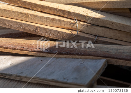 Wood pieces are piled in a construction site. Some pieces are rough and have different sizes. The scene shows part of a building project Wood pieces are piled in a construction site. Some pieces are rough and have different sizes. The scene shows part of a building project 139078186