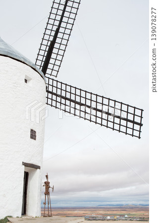 Traditional windmill in Spain with statue of Don Quixote in front of the door Traditional windmill in Spain with statue of Don Quixote in front of the door 139078277