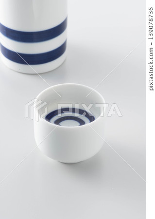 一張照片展現了將清酒從酒瓶倒入酒杯中品嚐的場景。 139078736