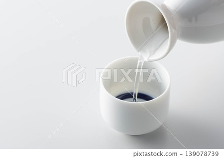一張照片展現了將清酒從酒瓶倒入酒杯中品嚐的場景。 一張照片展現了將清酒從酒瓶倒入酒杯中品嚐的場景。 139078739