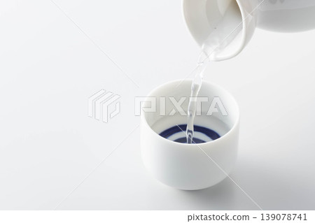 一張照片展現了將清酒從酒瓶倒入酒杯中品嚐的場景。 一張照片展現了將清酒從酒瓶倒入酒杯中品嚐的場景。 139078741