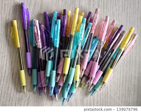 A large group of multi-colored automatic pens on a light background 139078796