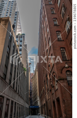 New york, usa august 15,2024. New york city manhattan downtown view showcasing a narrow urban street lined with traditional brick and modern high rise architecture 139078805