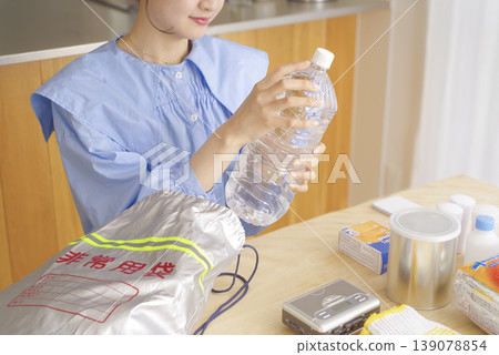 一名婦女正在檢查應急包中的物品 139078854