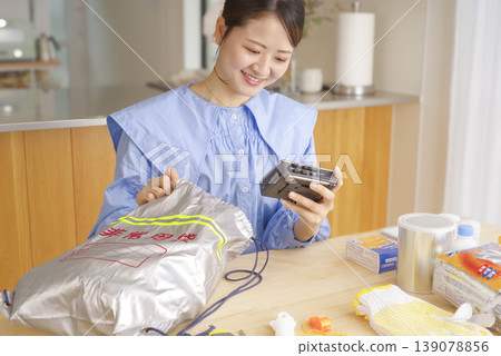 一名婦女正在檢查應急包中的物品 一名婦女正在檢查應急包中的物品 139078856