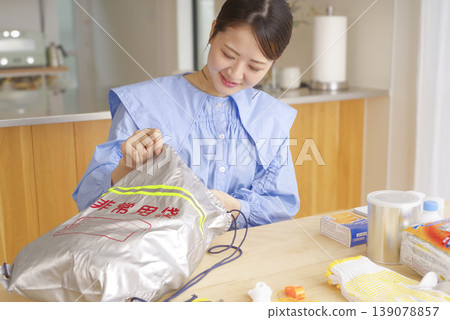 一名婦女正在檢查應急包中的物品 139078857