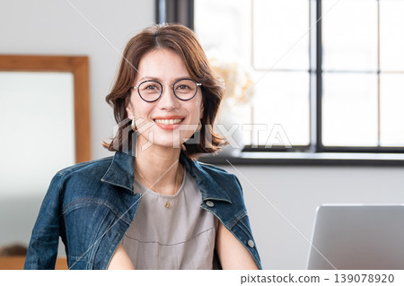 一位中年婦女在客廳使用電腦。 139078920