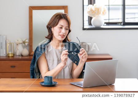 在客廳裡使用電腦的中年女人 在客廳裡使用電腦的中年女人 139078927