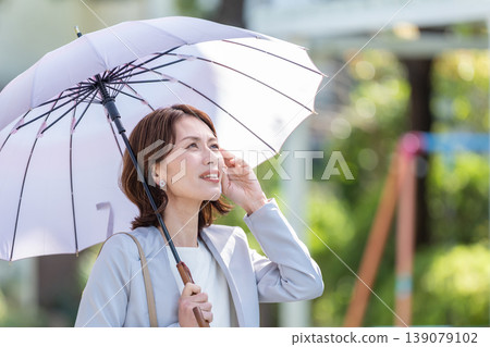 Business woman pointing a parasol Business woman pointing a parasol 139079102