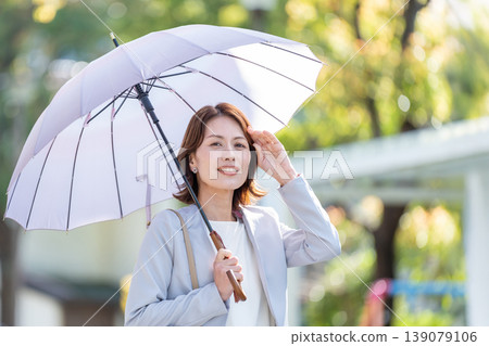 Business woman pointing a parasol Business woman pointing a parasol 139079106