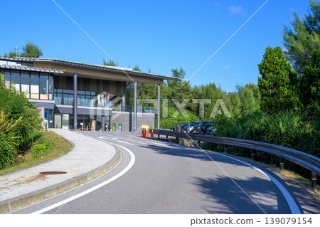 Exterior view of the Manzamo area revitalization facility, surrounded by blue sky and greenery. Exterior view of the Manzamo area revitalization facility, surrounded by blue sky and greenery. 139079154