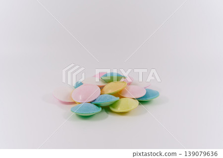 A pile of pastel-colored UFO candies placed on a white background. 139079636
