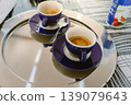 An espresso cup on a silver tray and the cup after finishing the drink. 139079643