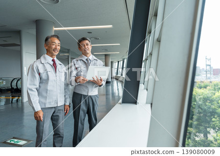一名身穿工作服的男子正在現場操作電腦。 139080009