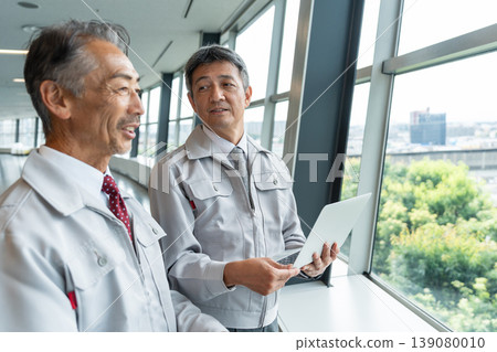 一名身穿工作服的男子正在現場操作電腦。 139080010